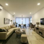 Elegant modern open-plan living and dining room with cozy furniture and warm lighting.