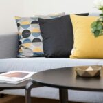 Contemporary living room interior featuring a stylish sofa, decorative pillows, and a vase of flowers.